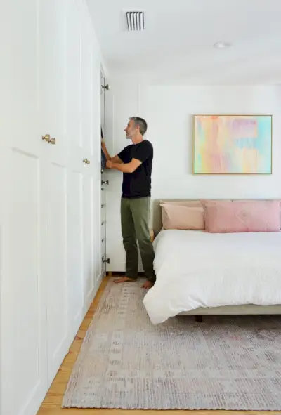 Man staat bij Ikea Pax kastmuur met kleurrijk roze schilderij