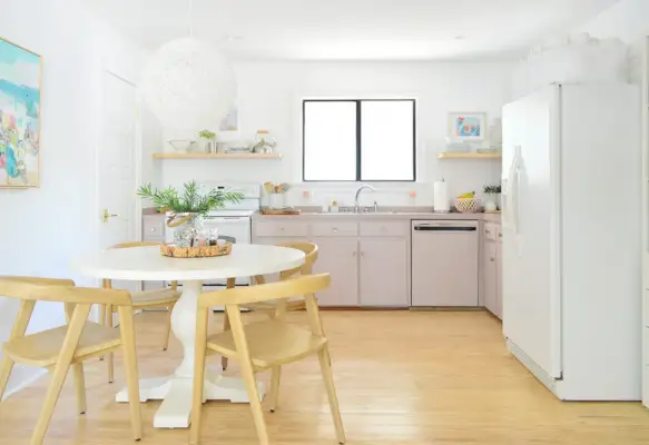 Minimale keuken met mauve geschilderde kasten en voetstuktafel
