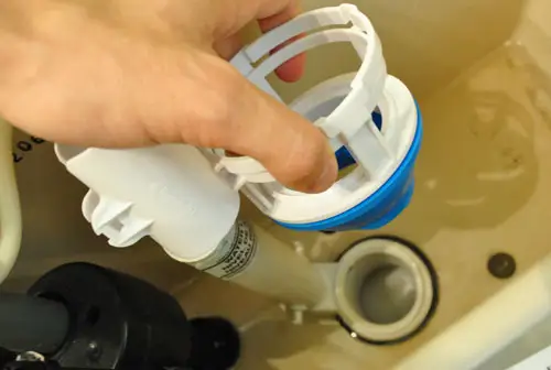 Schuifbare dubbele spoelomvormer op de pakking van de toilettank