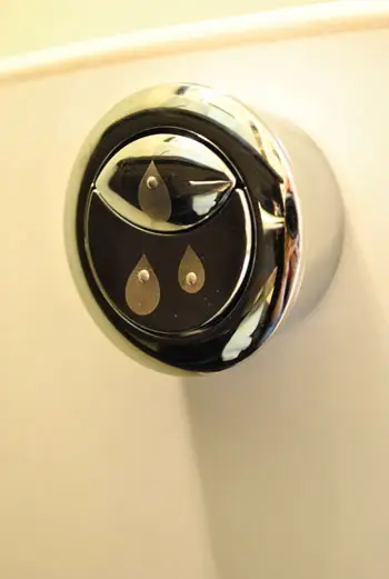 Toiletspoelknop met dubbele spoeling aan de zijkant van de toilettank