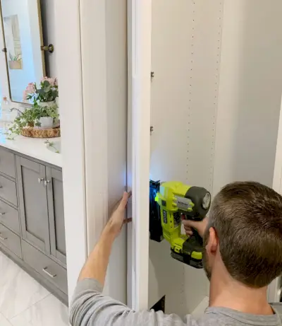 John spijkert de zijkant van een Ikea Pax-kledingkast vast om er ingebouwd uit te zien