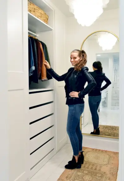 Sherry staat in een vernieuwde Ikea Pax Master Closet met gouden spiegel