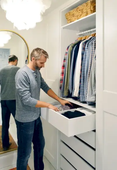 John haalt kleren uit het Ikea Pax ladesysteem