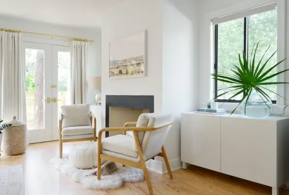 Witte Ikea Besta kast onder raam in slaapkamer achter stoel