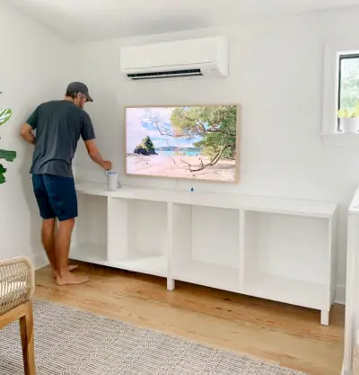 John bezig met het installeren van Ikea Besta-kasten in de familiekamer