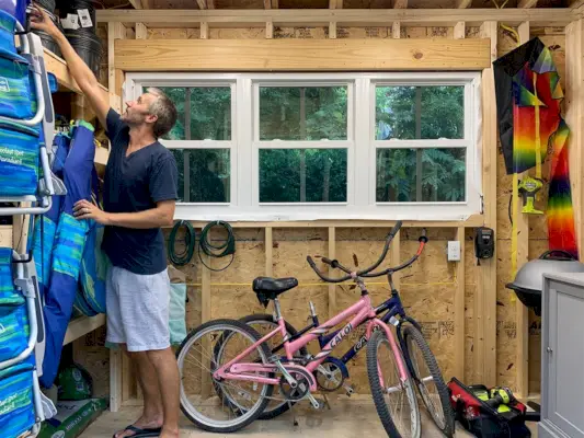 John reikt naar iets in de schuur van het strandhuis