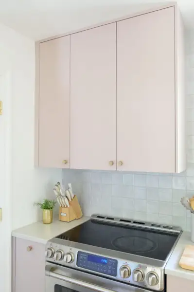 Bovenkast in geschilderde Ikea-keuken met verborgen Omsinnad-kap boven fornuis