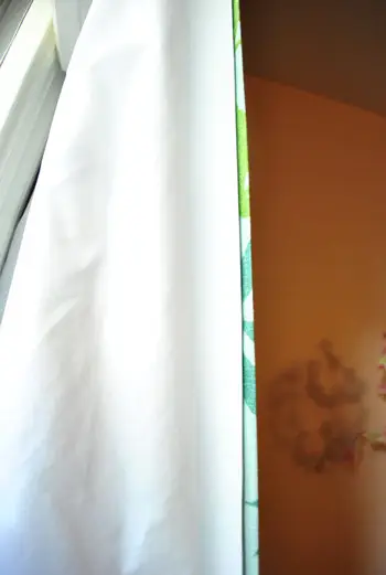 close-up van verduisteringsgordijnvoeringstof geplaatst achter gordijnpaneel bij een meisje