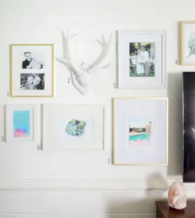 mix van foto's, kunst en objecten om een eclectische fotowand rond een tv te creëren