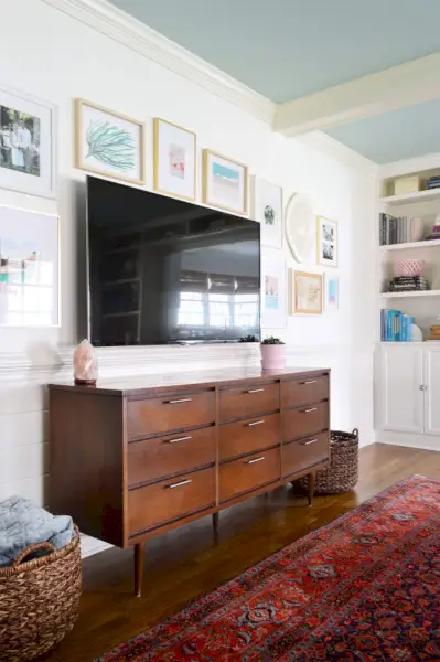 televisie aan de muur gemonteerd met een fotolijst eromheen
