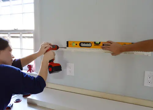 Zorg ervoor dat de ophangbeugel voor de zwevende plank van Ikea waterpas staat terwijl u hem aan de muur vastschroeft