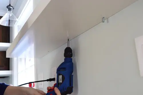 Gebruik een boormachine om de zwevende Ikea-plank vast te schroeven en aan de muurbeugel te bevestigen