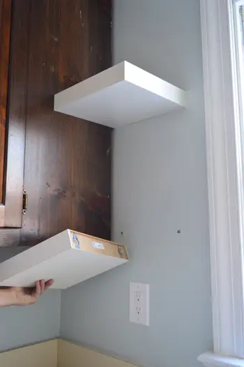 laat zien hoe korte Ikea LACK zwevende planken aan de keukenmuur zijn bevestigd
