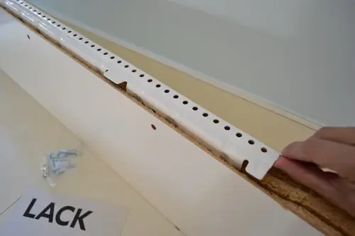 close-updetail van witmetalen ophangbeugel voor LACK Ikea zwevende plank