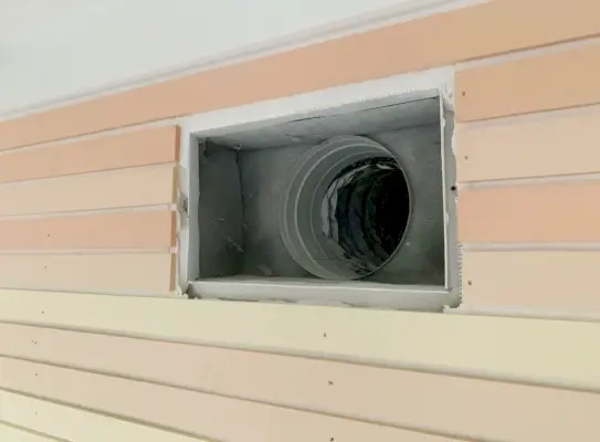 Deksel van de ventilatieopening aan de muur is verwijderd om te laten zien hoe het hout rond de obstructie is gesneden