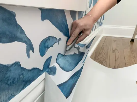 Overtollig Peel-and-Stick-behang langs de plint afsnijden
