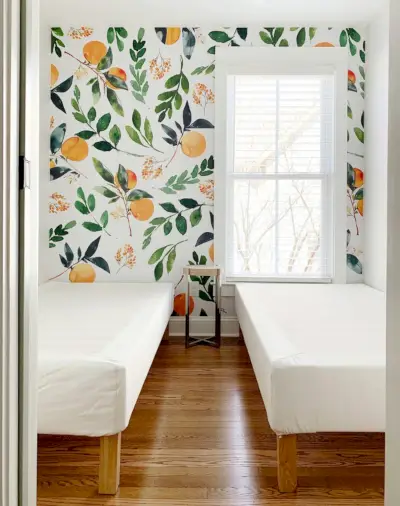 Peel-and-stick muurschildering met sinaasappelen in een kamer met twee eenpersoonsbedden