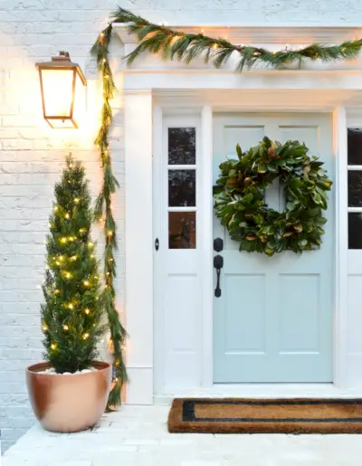Close-up van de veranda met geschilderde blauwe deur versierd voor Kerstmis
