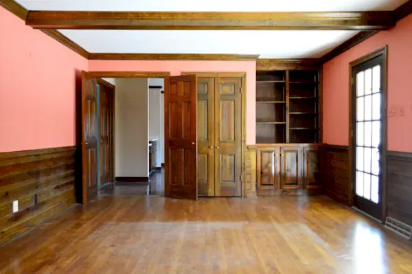 ingebouwde boekenplank in woonkamer met houten lambrisering