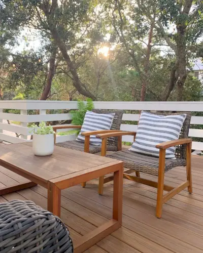 Zon gluren door bomen boven dek lounge stoelen