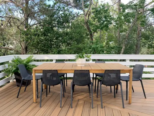 Metalen buiteneettafel met acht zwarte plastic stoelen