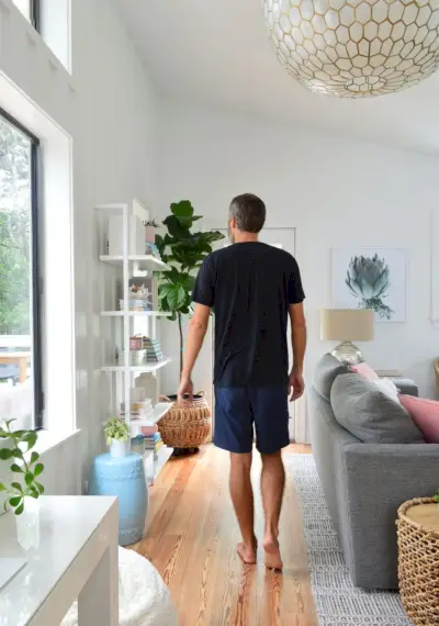 Man In Zwart Shirt Lopen In De Woonkamer Onder Grote Lichtpunt