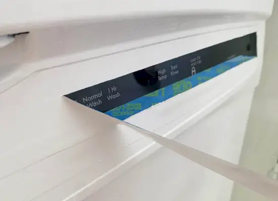 Afpellen van de tape van de bedieningselementen van de vaatwasser na het zwart-wit verven