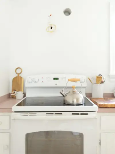 Lege muurruimte boven witte kachel in minimale witte keuken