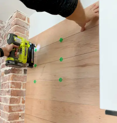 Spijkerpistool waarmee houten panelen aan de achterwand worden bevestigd met behulp van tegelafstandhouders