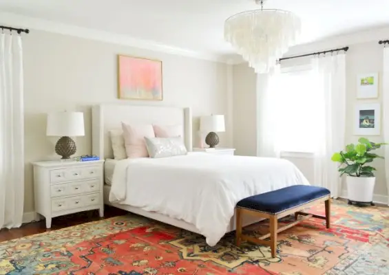 hoofdslaapkamer met licht gestoffeerd bed en witte ikea-gordijnen