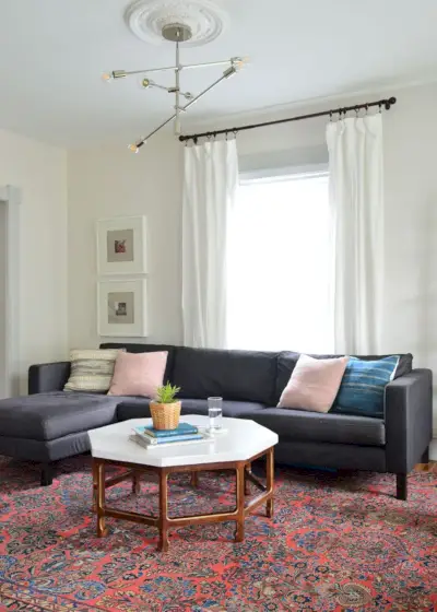 grijze muurwoonkamer met rood vintage tapijt en donker marineblauwe ikea-sectie
