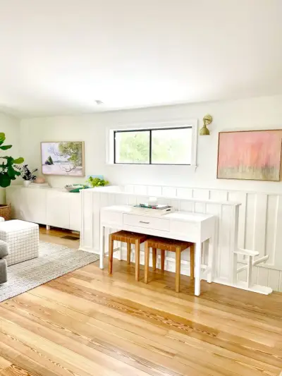 Consoletafel bij trap in moderne familiekamer boven met witte lambrisering