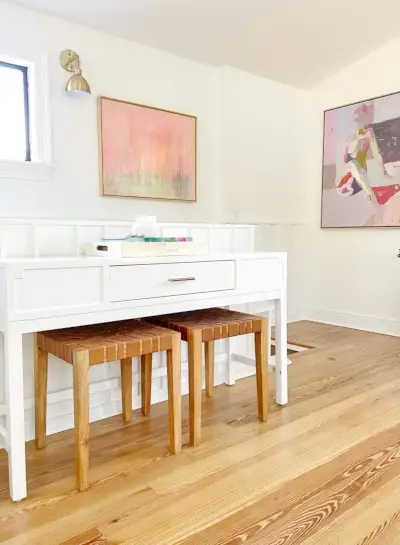 Consoletafel in de moderne familiekamer op de bovenverdieping met leren banken en ingelijste schilderijen op de achtergrond