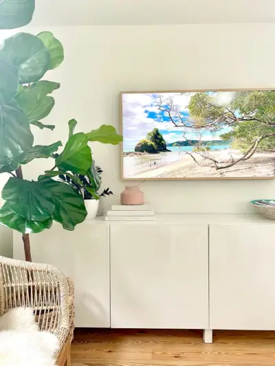Samsung Frame-tv boven Ikea Besta-console in moderne familiekamer met nep-vijgenboom