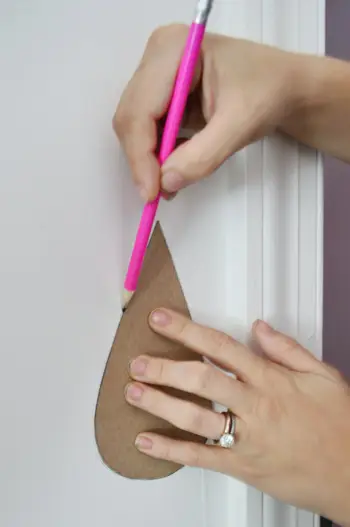 Regendruppels op de muur traceren met potlood met behulp van kartonnen sjabloonvorm