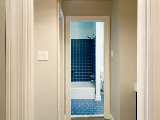 Vóór foto van badkamer gescheiden door muren met blauwe tegels