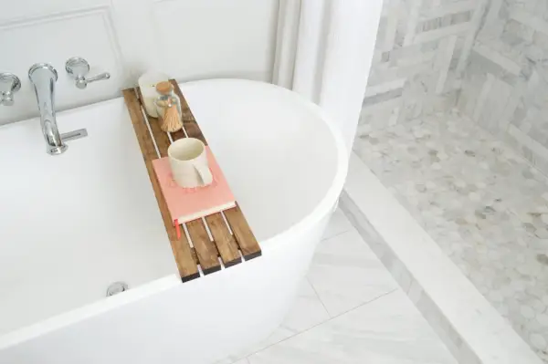 Bovenaanzicht van dienblad boven vrijstaand bad in moderne traditionele badkamer