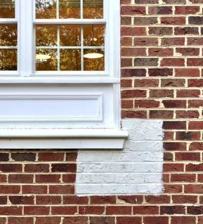 modern wit verfmonster op rood bakstenen huis