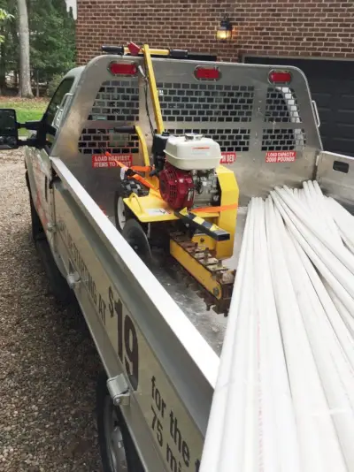 Home Depot-truck met PVC-buis en sleuvengraver achterin