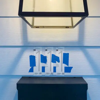 Huisnummersjablonen meegeleverd, vastgeplakt aan de muur voor plaatsing