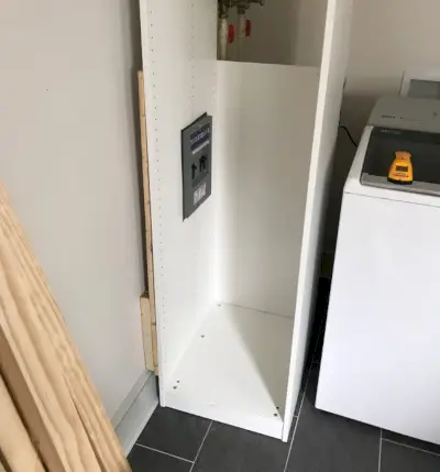 Ikea pax kledingkast tegen de muur gedrukt met uitsparingen voor de zekeringkast