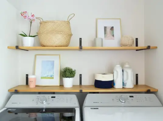 open planken boven de wasruimte met donkere ijzeren beugels en houten planken