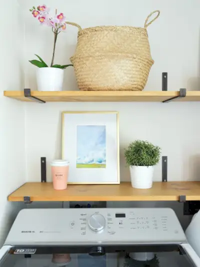 detail van open planken boven de wasmachine met kunstmandorchidee