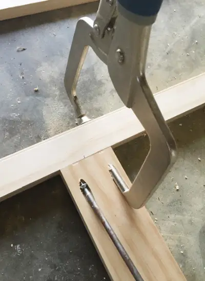 Een Kreg-malklem die wordt gebruikt om twee stukken hout in een rechte hoek aan elkaar te bevestigen met behulp van een zakgatschroef
