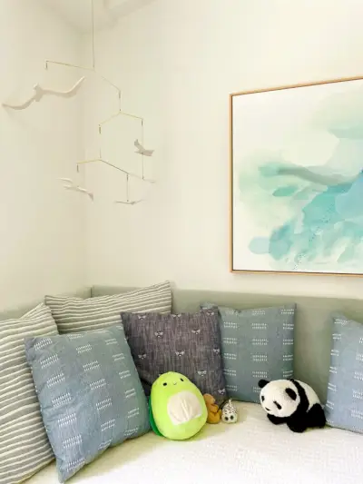 Bed tegen de muur met gestoffeerde panelen erachter voor een daybed-look