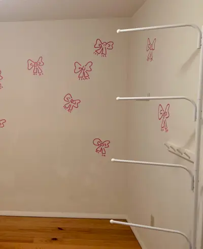 Voor foto van jongensslaapkamer met geschilderde strikmuurschildering op witte muren