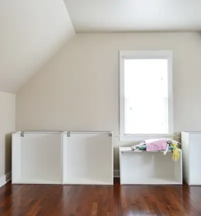Kamer met schuin plafond en Ikea-kasten in aanbouw, met een meisje