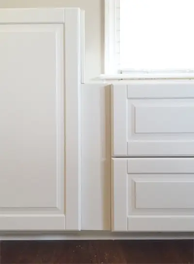 opvulstuk tussen twee witte Ikea Sektion kasten met Bodbyn deuren waardoor er een inbouwplek ontstaat tussen deuren en lades