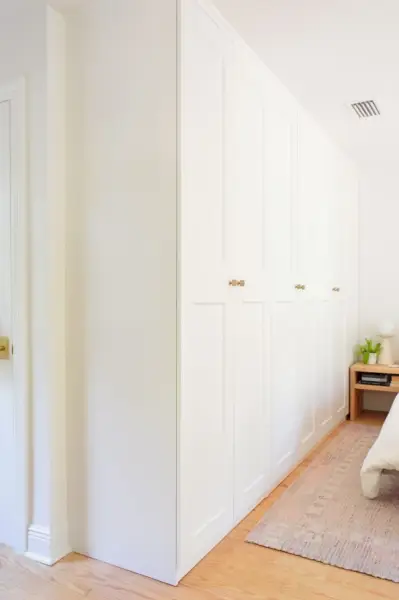 Hoek van de muur van Ikea Pax-garderobekasten met Grimo-deuren
