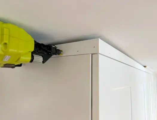 Spijkerversiering aan de bovenkant van de ingebouwde Ikea Pax-kledingkast